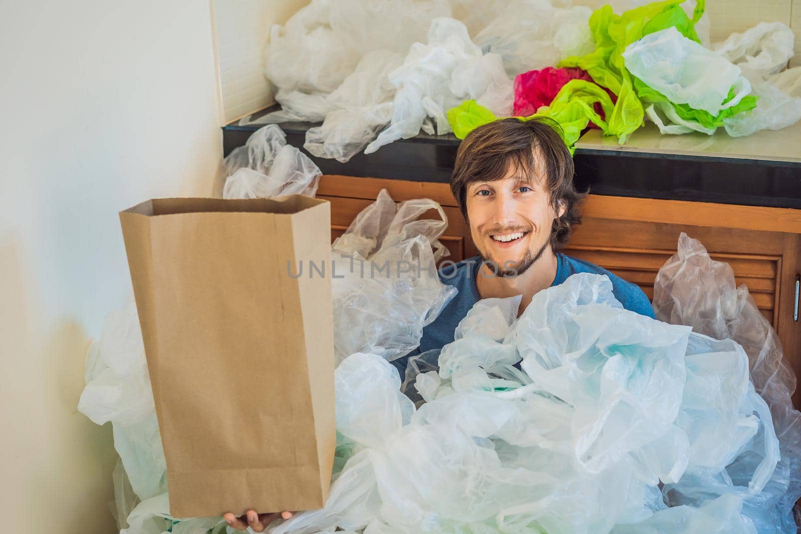 Man holding paper bag amid a pile of plastic bags. Zero waste concept. The concept of World Environment Day.