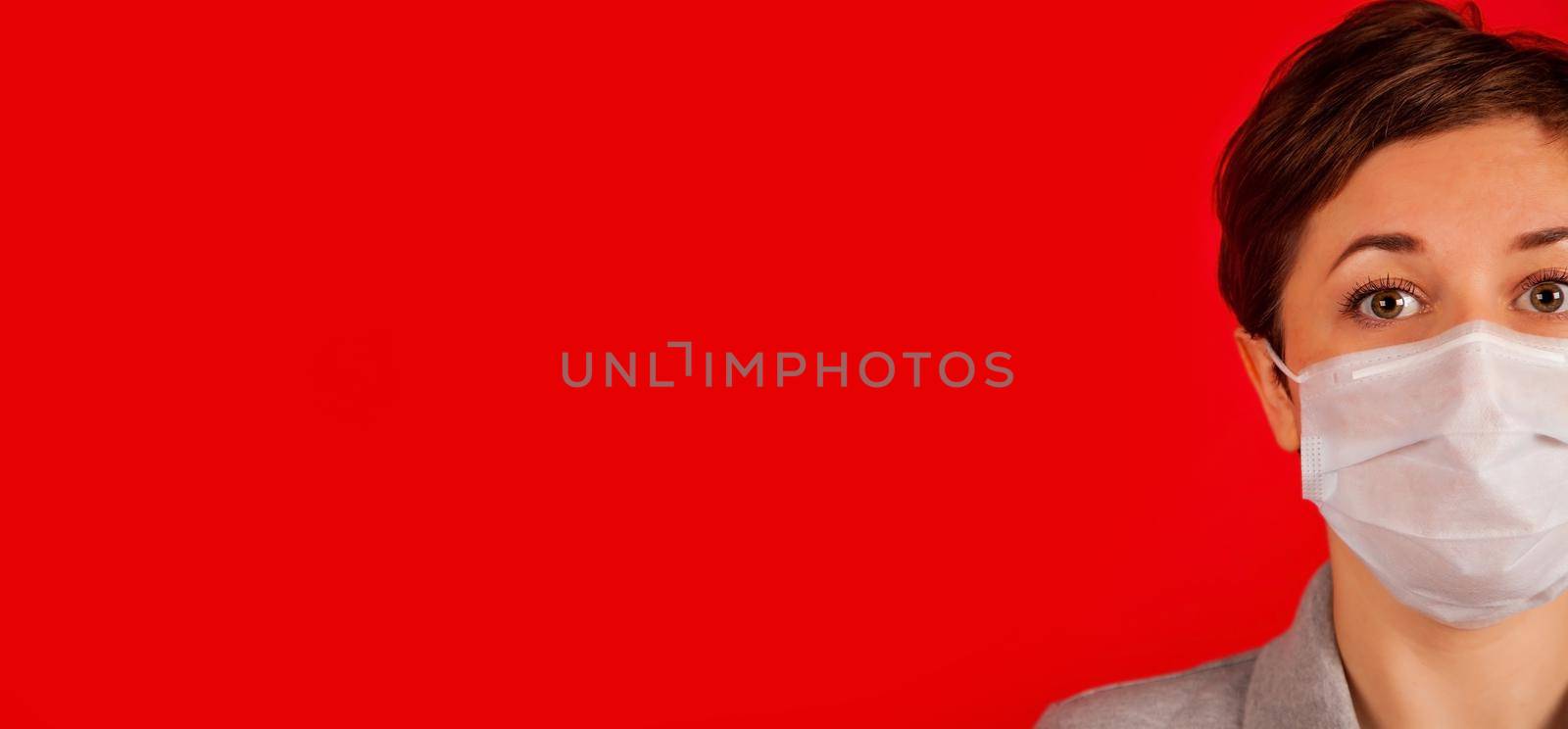 Woman in a medical mask on a red background. The concept of protection against viruses, influenza and coronavirus COVID-19. Health care and surgical concept.