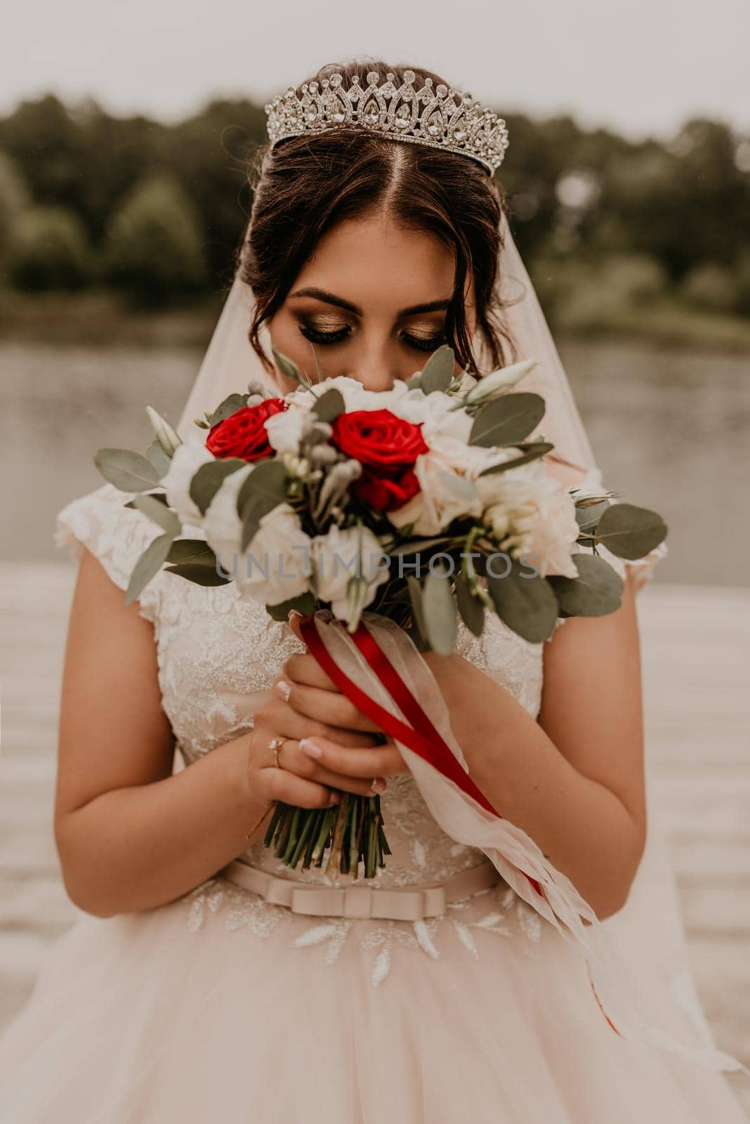 European Caucasian young black-haired woman bride girl holding her bouquet flowers in hands. by AndriiDrachuk