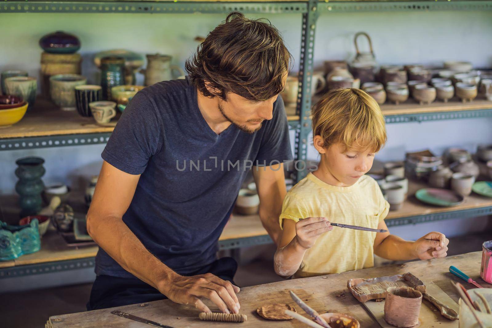 Father and son doing ceramic pot in pottery workshop.