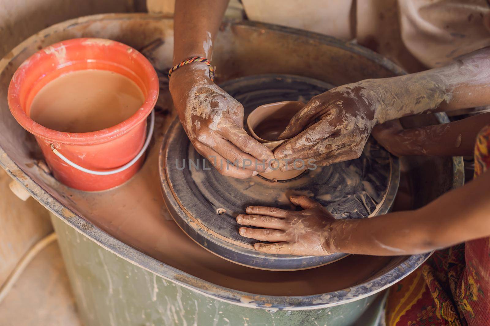 Father and son doing ceramic pot in pottery workshop by galitskaya