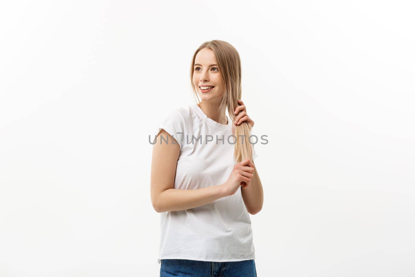 Hair care. Young Caucasian girl combing hair with finger isolated on white background by Benzoix
