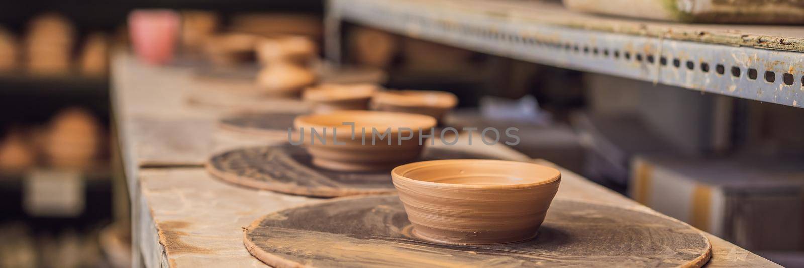 Cups on the shelves in the pottery workshop BANNER, LONG FORMAT by galitskaya