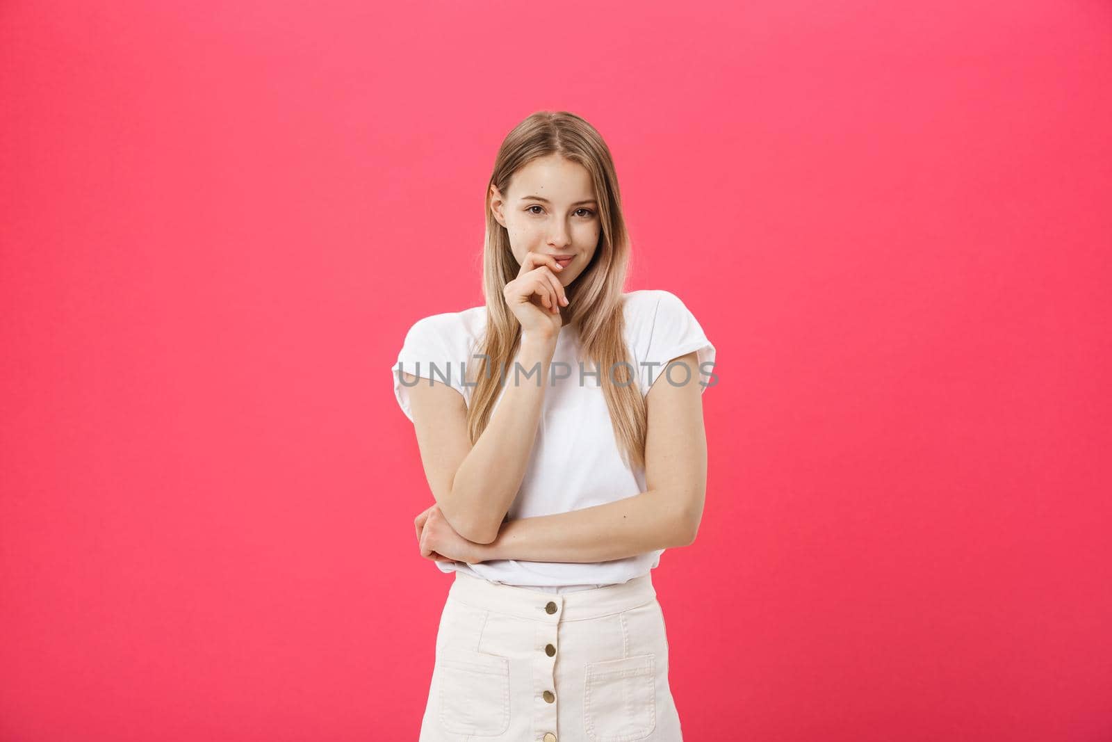 Trendy young female wearing casual clothes posing over pink background.