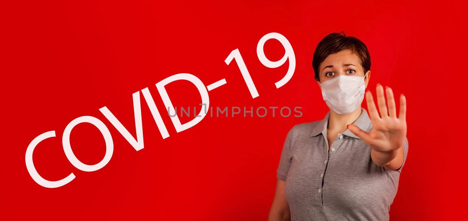 A woman in a mask indicates stopping the spread of the COVID-19 virus. The concept of preventing the spread of the epidemic and treating coronavirus. Coronavirus treatment.