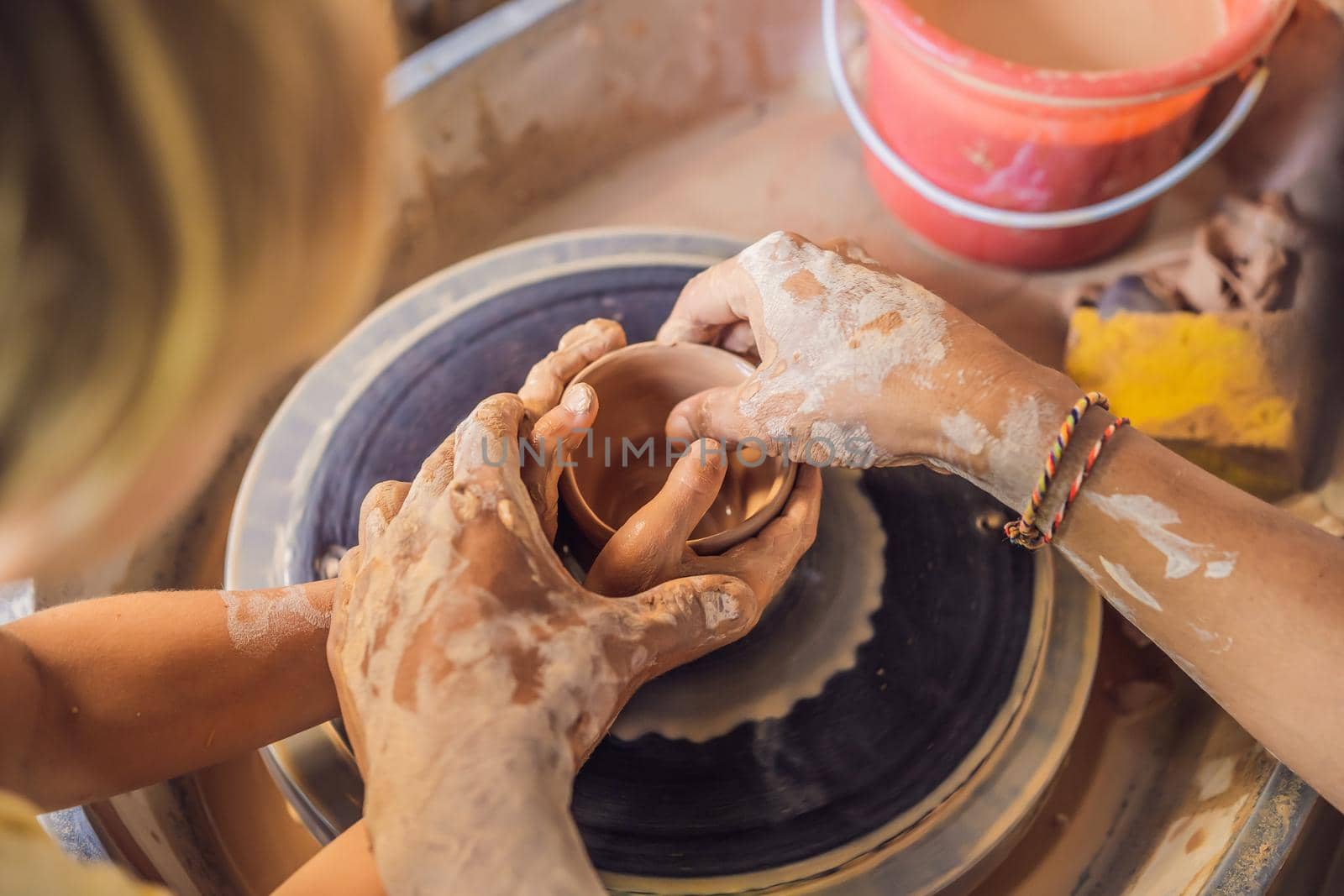 Father and son doing ceramic pot in pottery workshop by galitskaya