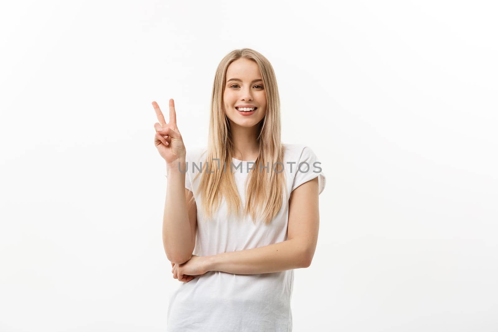 Closeup portrait young happy confident woman giving peace victory, two sign gesture, isolated white studio background. Positive emotion facial expression feelings symbols, attitude.