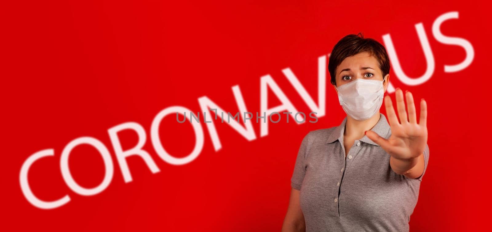 A woman in a mask indicates stopping the spread of the COVID-19 virus. The concept of preventing the spread of the epidemic and treating coronavirus. Coronavirus treatment.