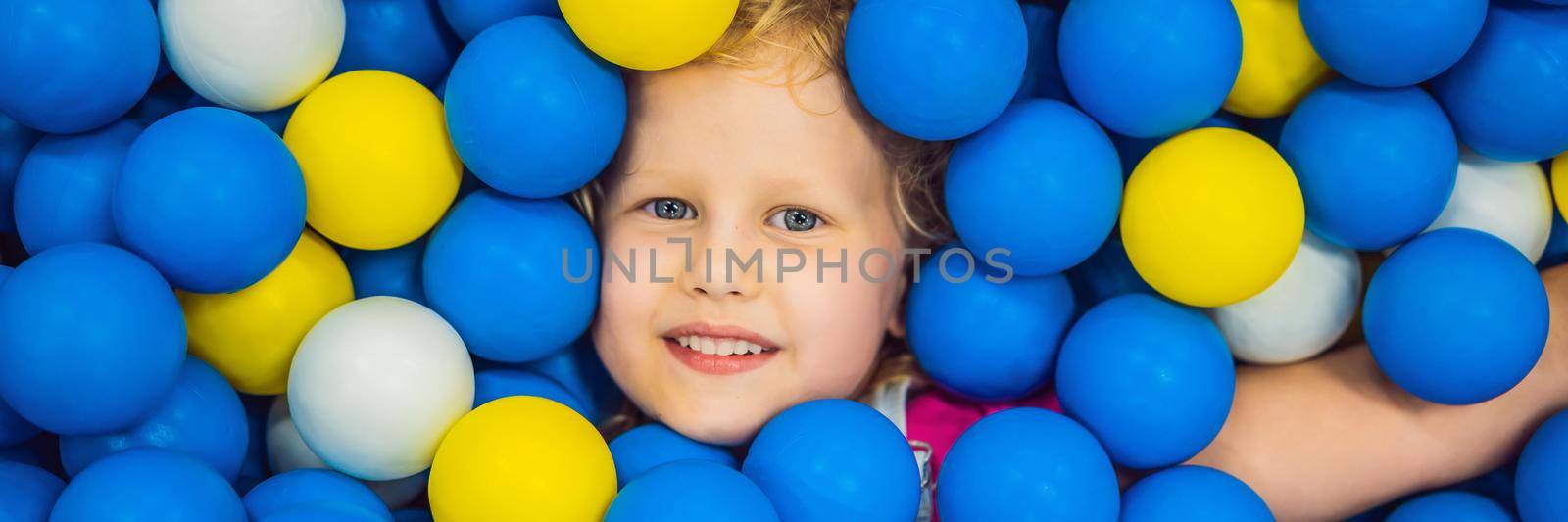 BANNER, LONG FORMAT Child playing in ball pit. Colorful toys for kids. Kindergarten or preschool play room. Toddler kid at day care indoor playground. Balls pool for children. Birthday party for active preschooler by galitskaya