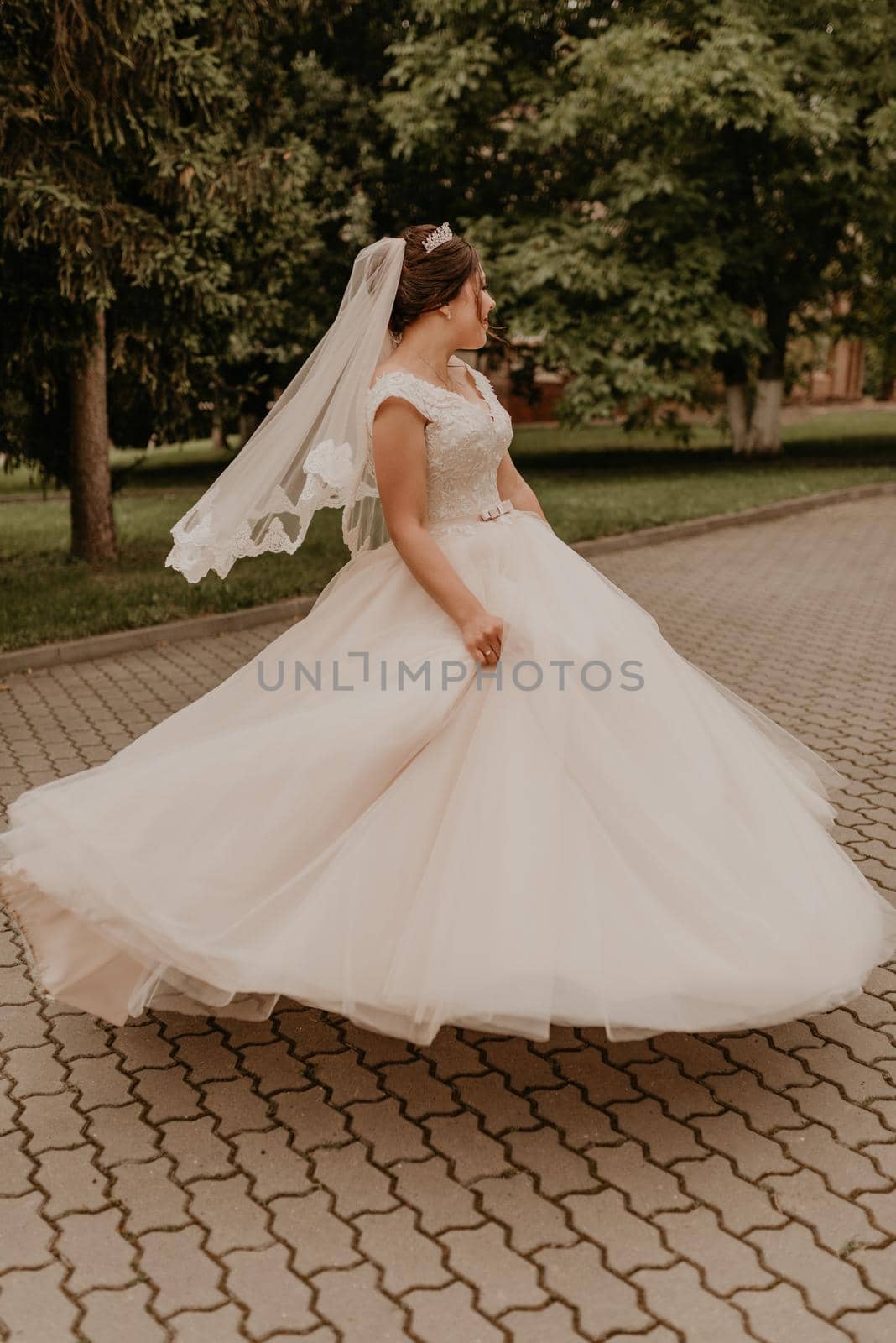 Caucasian young woman bride spinning whirls dancing posing moving at nature by AndriiDrachuk