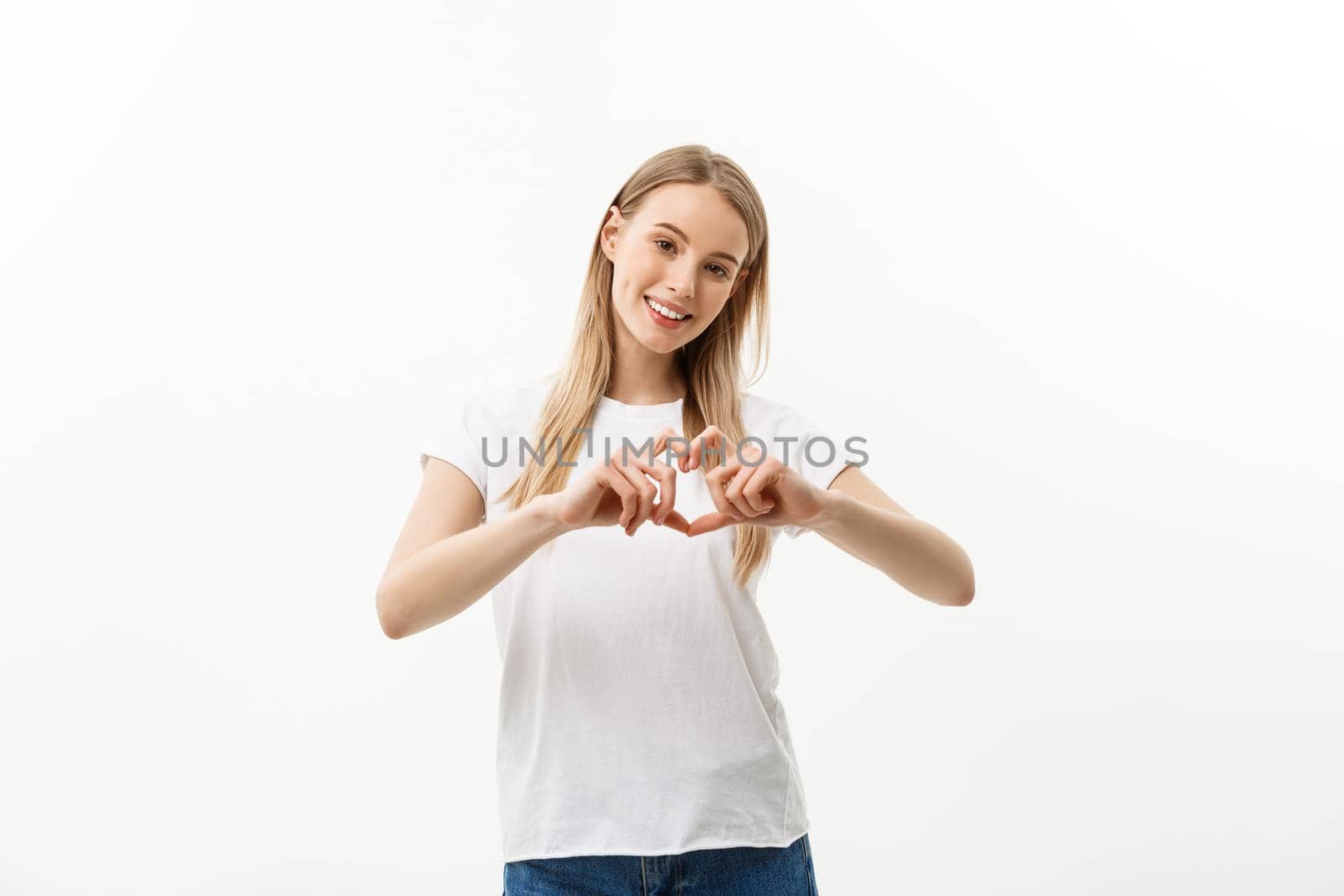 Isolated portrait of beautiful caucasian woman make heart symbol by hands. White studio background. Copy Space. by Benzoix