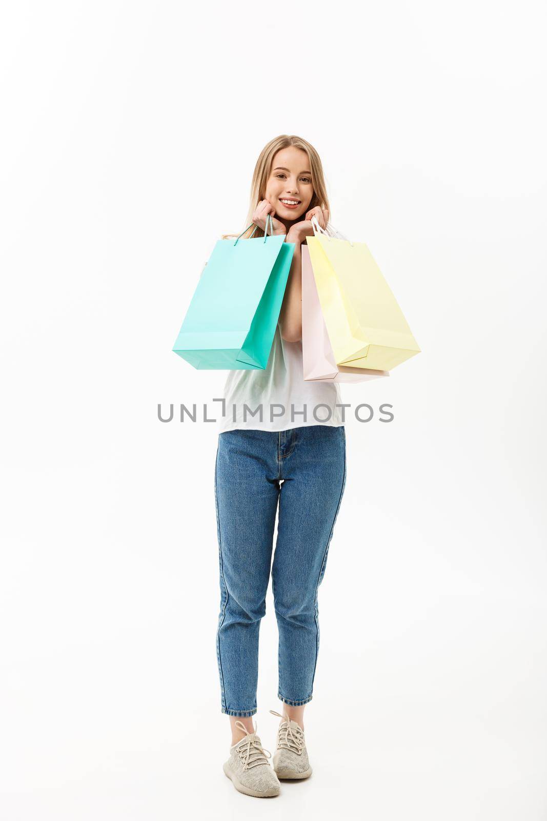 Full length of Shopper woman holding shopping bags standing happy smiling and excited in full body isolated on white background. by Benzoix