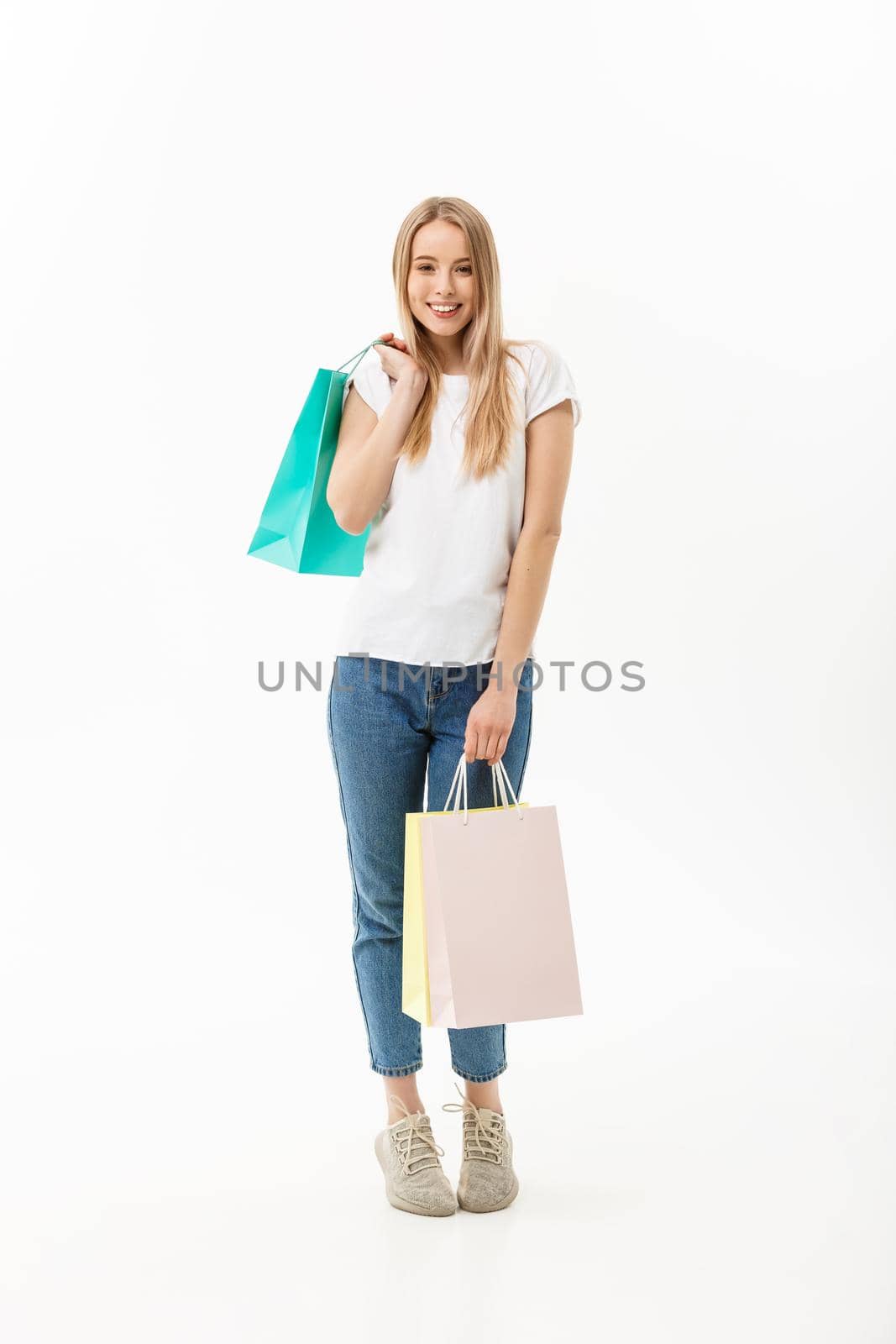 Full length portrait of a beautiful young woman posing with shopping bags, isolated on white background by Benzoix