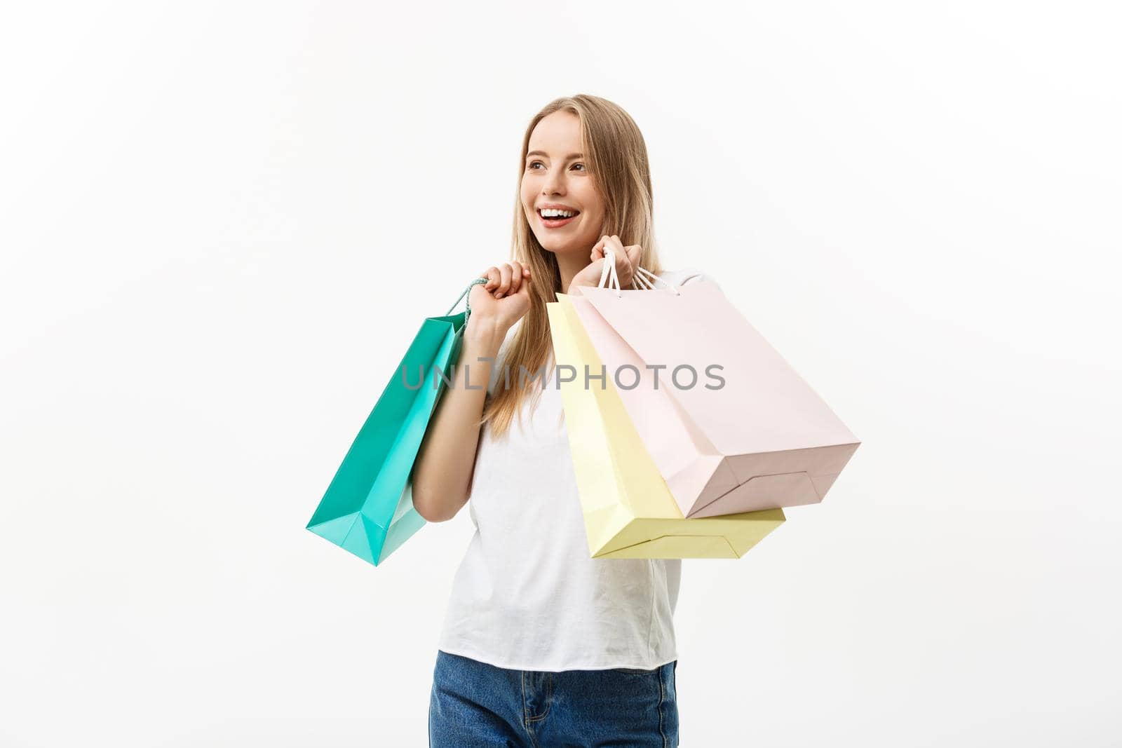 Shopping and Lifestyle Concept: Young happy summer shopping woman smiling and holding shopping bags isolated on white background by Benzoix