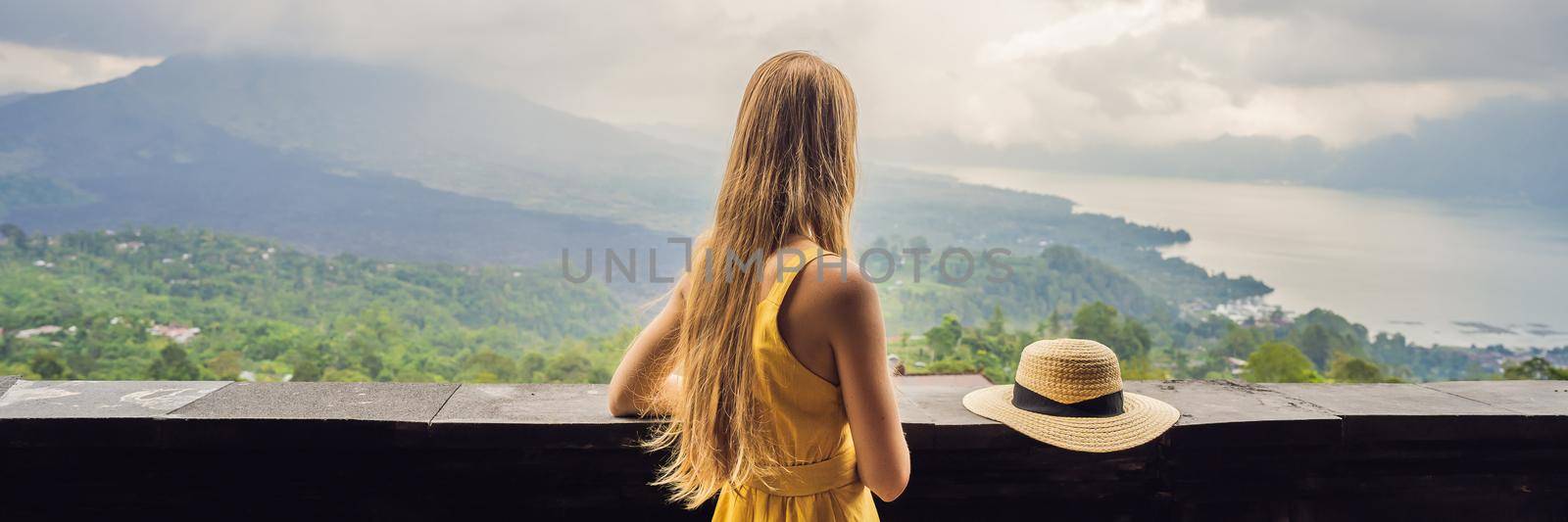 Woman traveler looking at Batur volcano. Indonesia. BANNER, LONG FORMAT