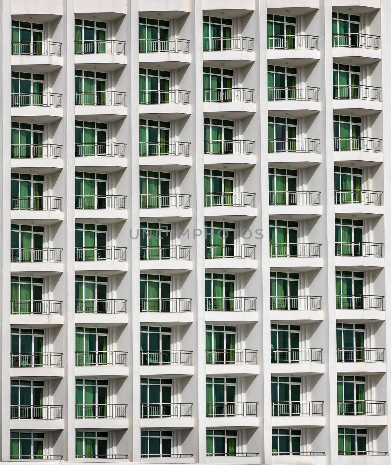 a repeating pattern of windows and a balcony. Windows of a hotel building.   by EdVal