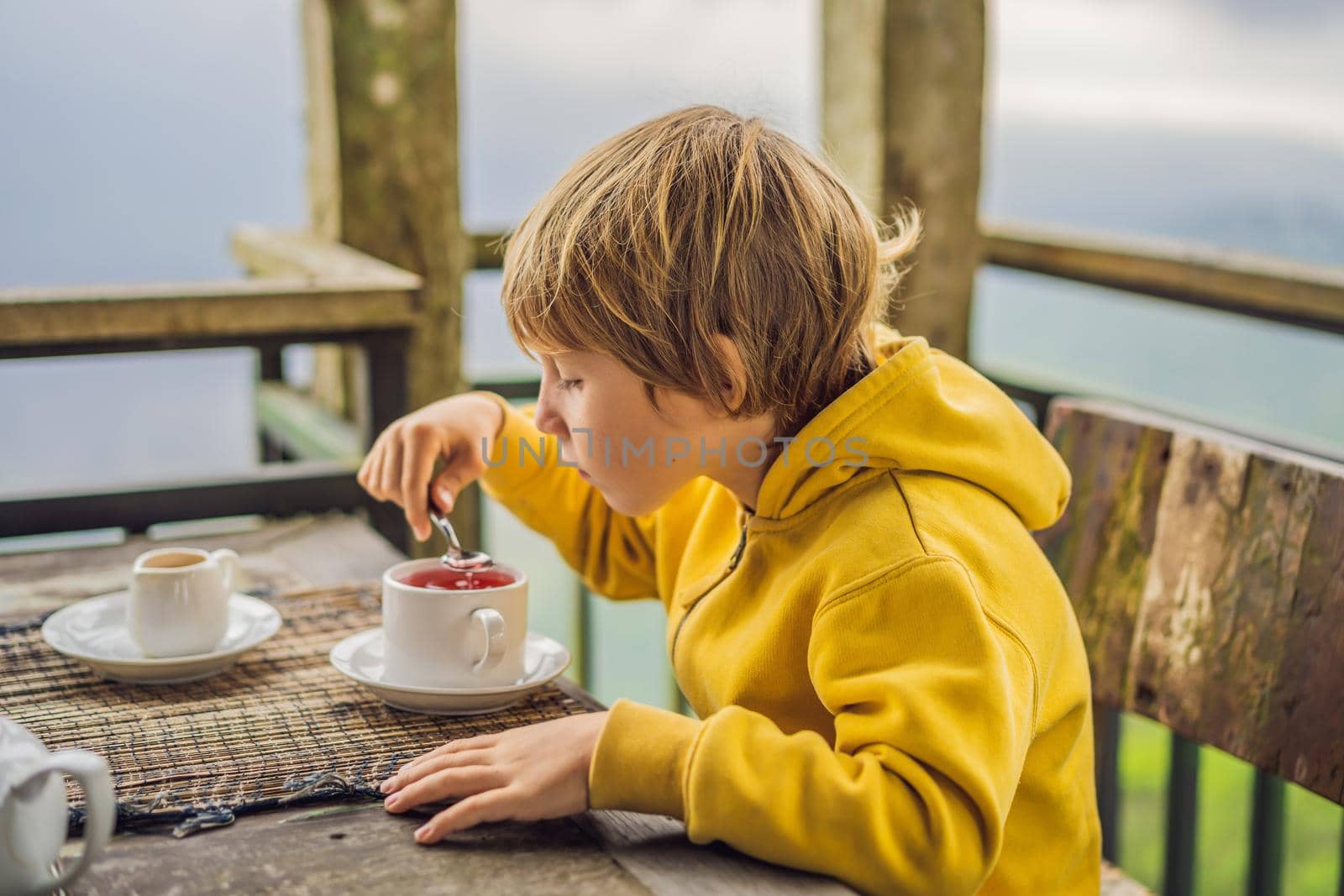 Boy drinking tea in a cafe in the mountains.