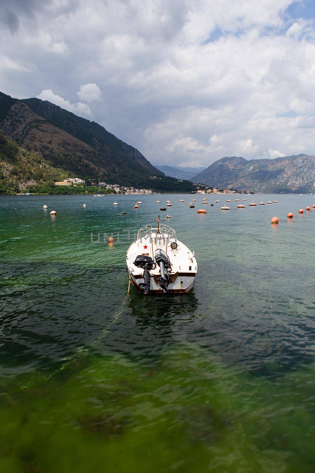 Very beautiful embankment of the Bay of Kotor, a small fishing boat. Montenegro. A beautiful and cozy city, tiled houses. The concept of rest and vacation in Europe. by sfinks