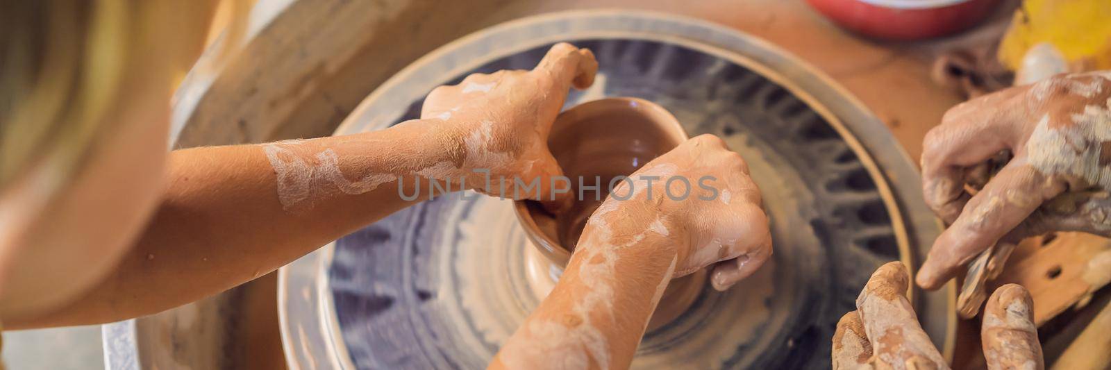 Father and son doing ceramic pot in pottery workshop. BANNER, LONG FORMAT