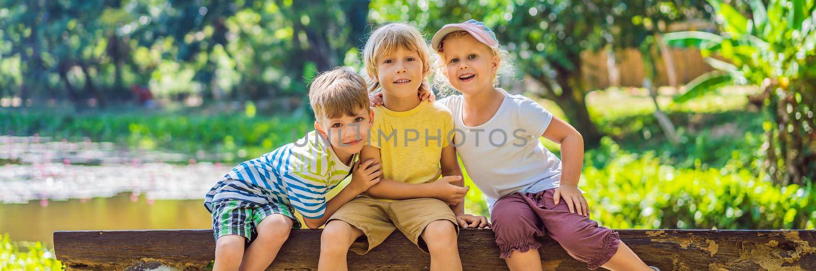 Children rest during a hike in the woods. BANNER, LONG FORMAT