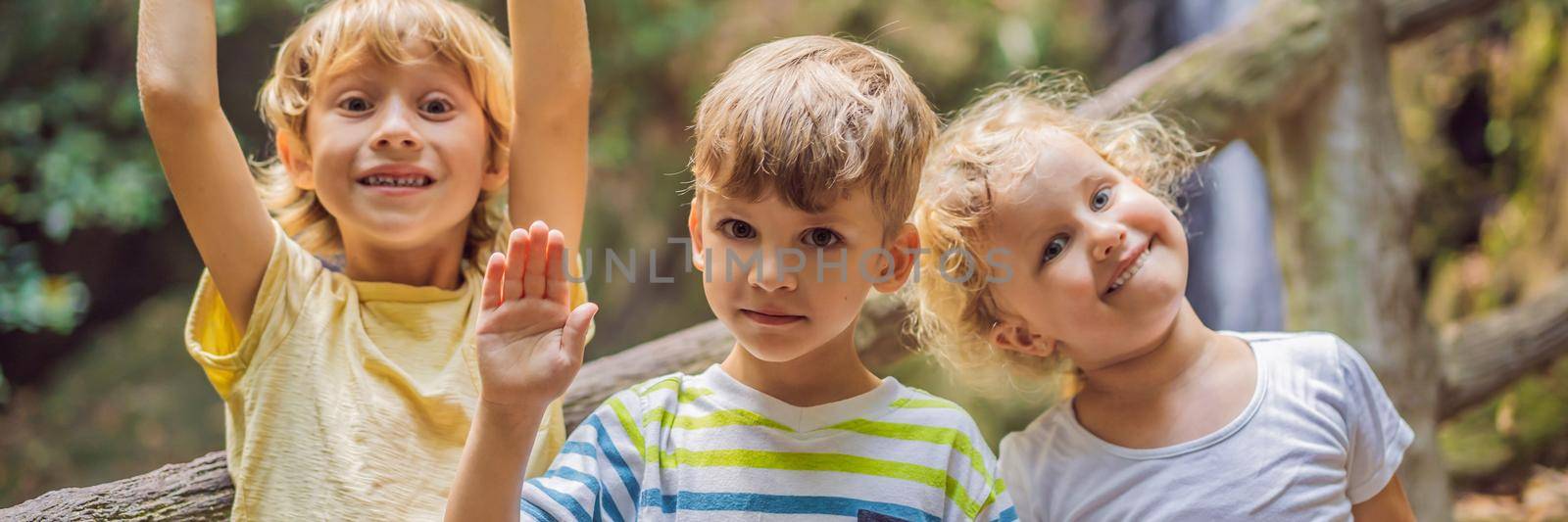 Children rest during a hike in the woods. BANNER, LONG FORMAT