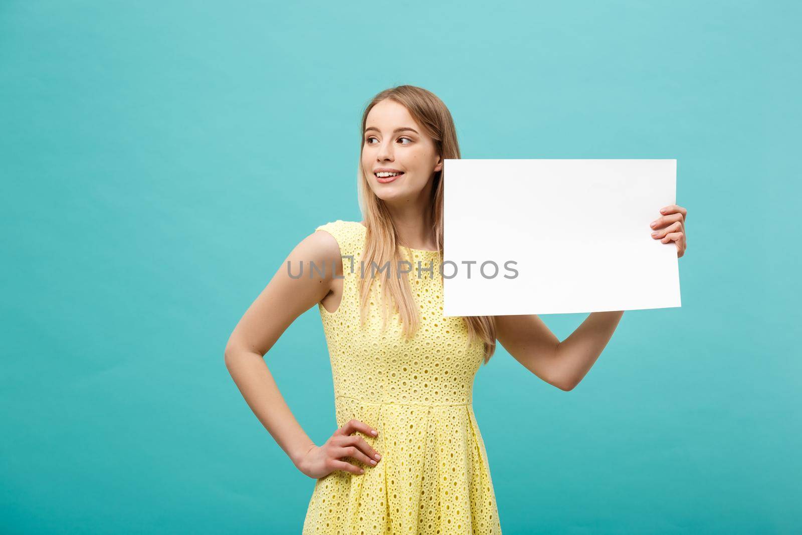 Portrait beautiful young caucasian woman holding a blank paper isolated on pastel blue background by Benzoix