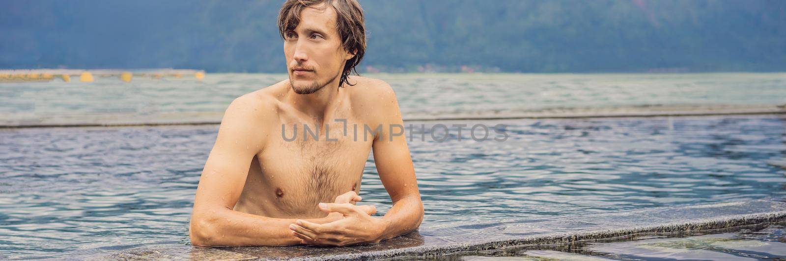 Geothermal spa. Man relaxing in hot spring pool. Young man enjoying bathing relaxed in a blue water lagoon, tourist attraction. BANNER, LONG FORMAT