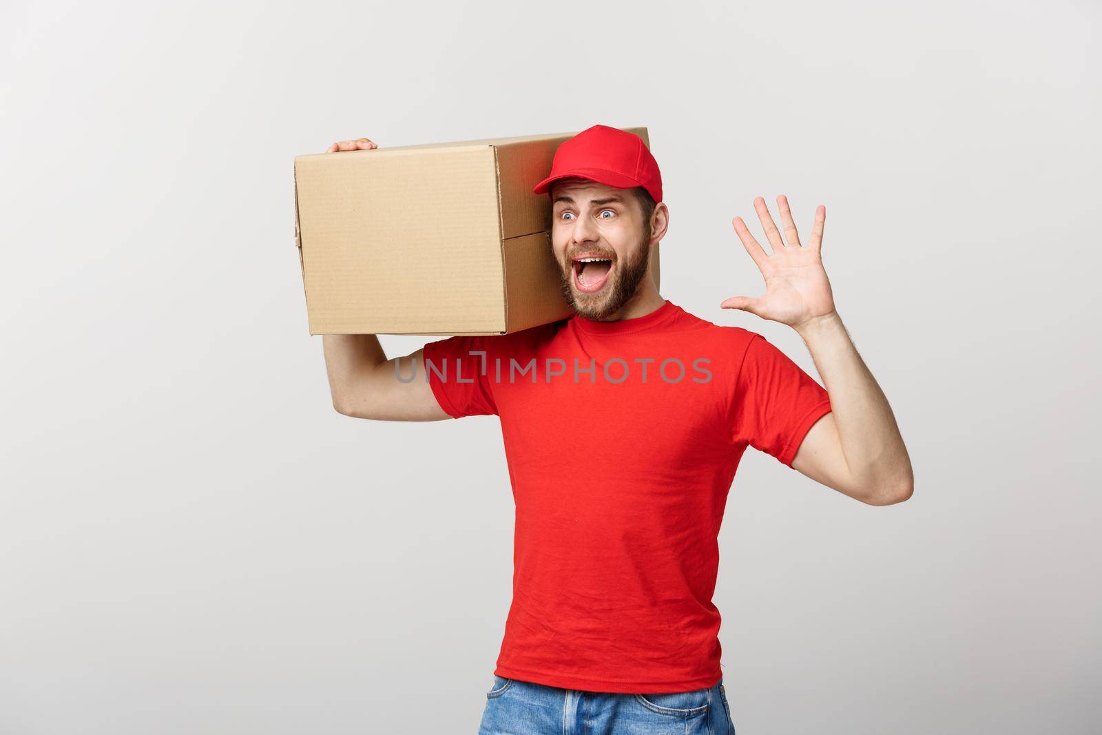 Delivery man doing surprise gesture holding cardboard boxes