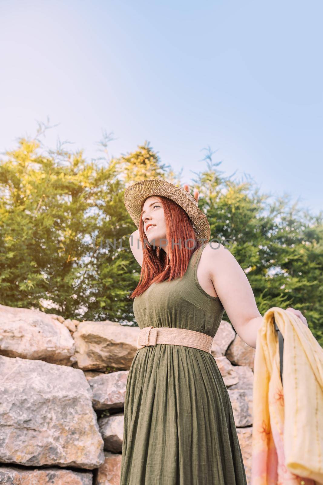 intrepid and adventurous young girl, having fun on her summer holiday. traveller walking at her vacation destination. trip, hobby, leisure, travelling tourist, outside, natural sunlight, vertical.