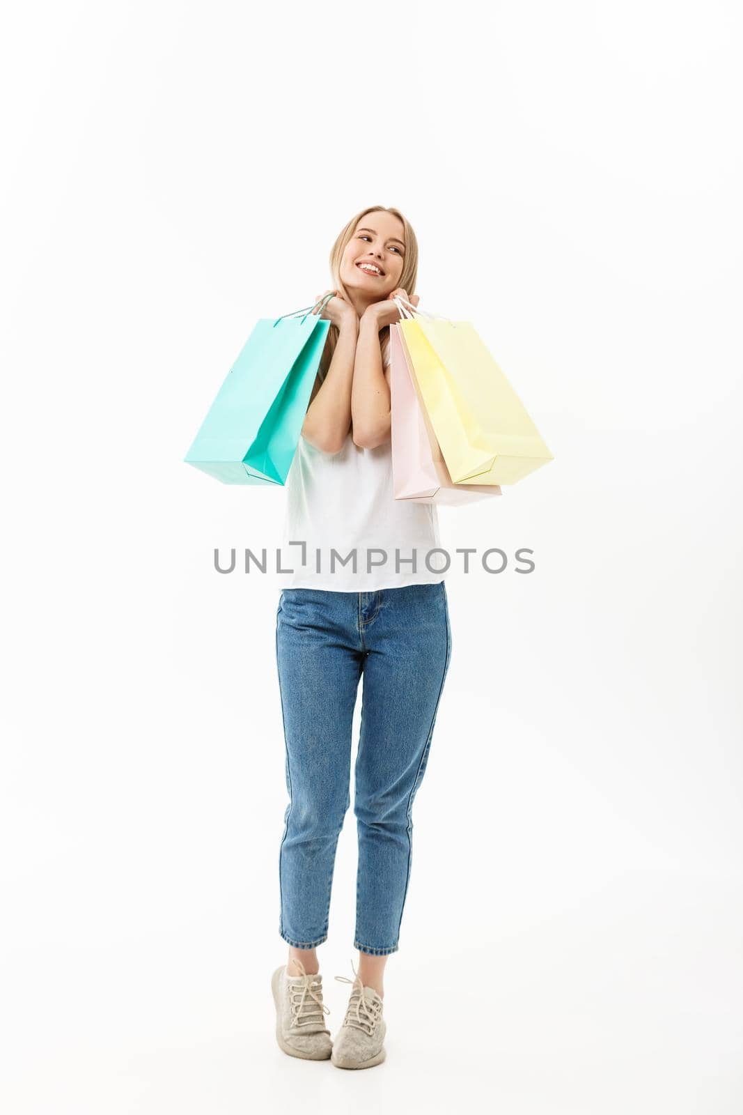 Full length portrait of a beautiful young woman posing with shopping bags, isolated on white background by Benzoix