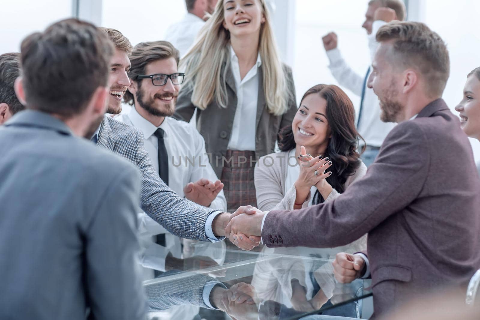 smiling business partners shaking hands, to the applause of the business team. concept of cooperation