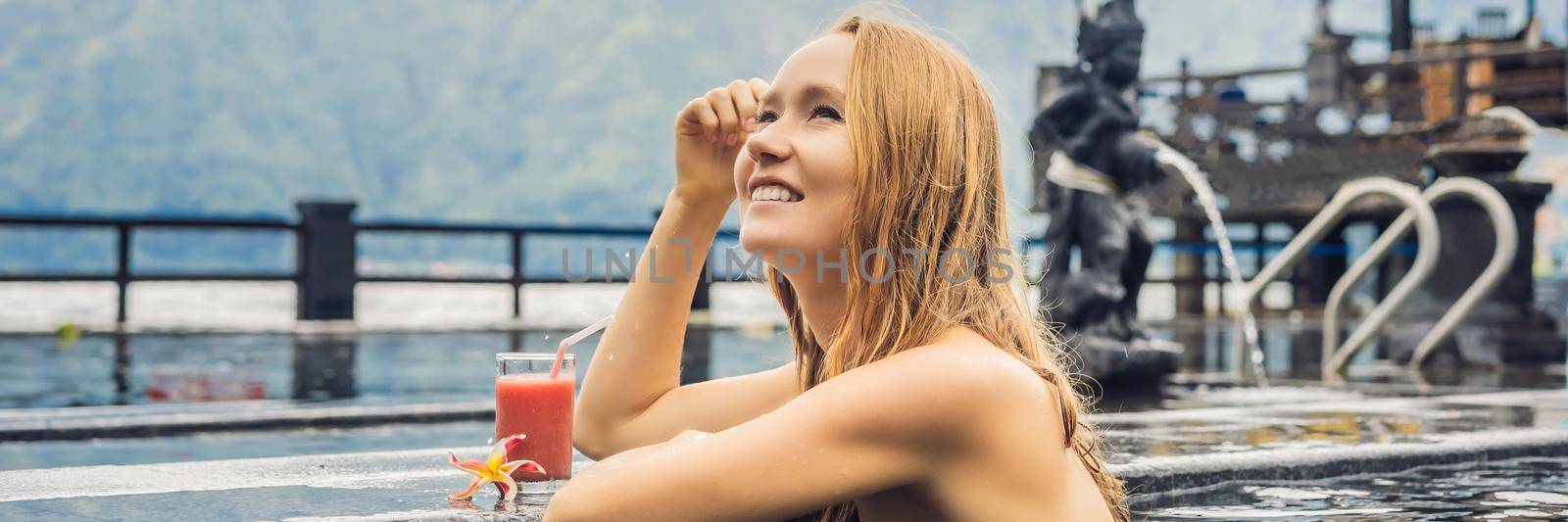 Geothermal spa. Woman relaxing in hot spring pool against the lake. hot springs concept. Drinking guava juice BANNER, LONG FORMAT by galitskaya