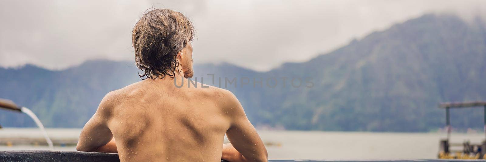Geothermal spa. Man relaxing in hot spring pool. Young man enjoying bathing relaxed in a blue water lagoon, tourist attraction BANNER, LONG FORMAT by galitskaya