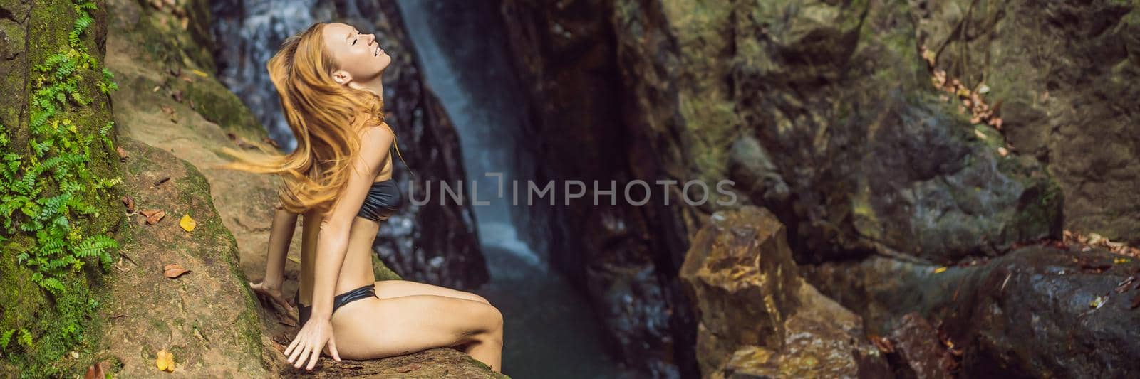 Young beautiful woman standing in the water at the waterfall. BANNER, LONG FORMAT