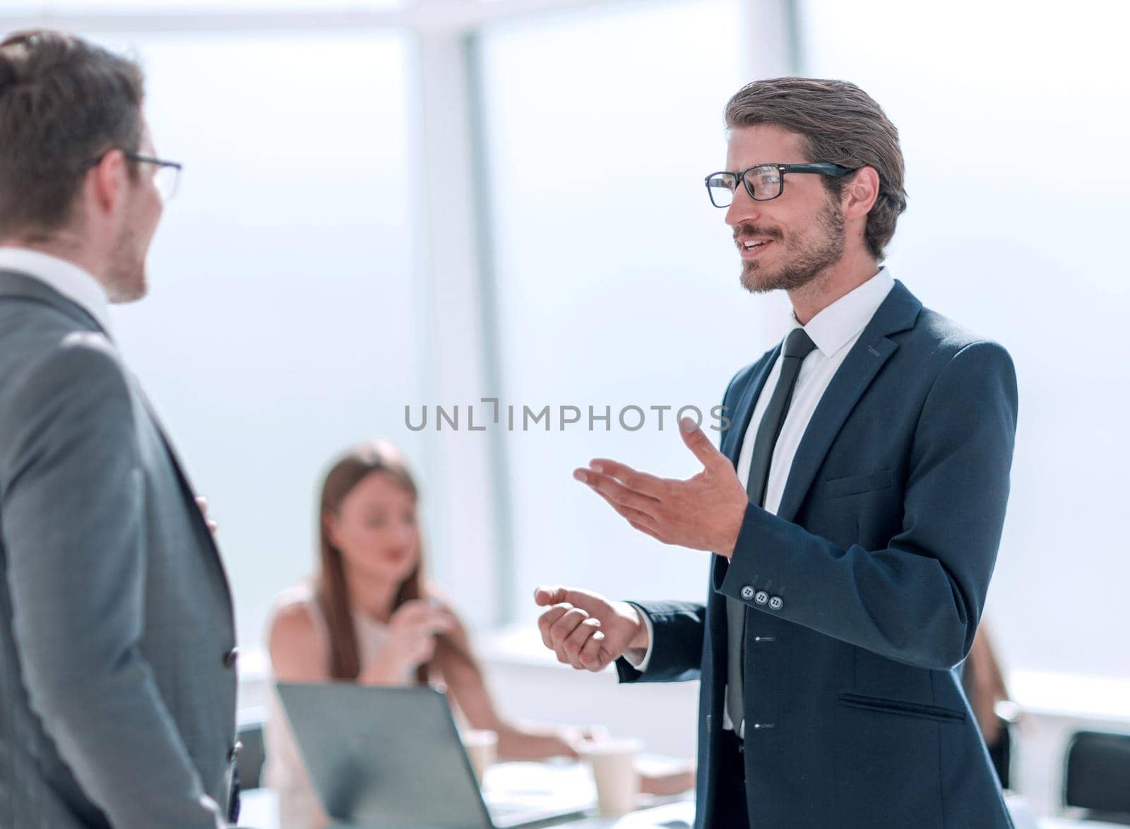 businessman explaining something to his colleague standing in the office. office weekdays