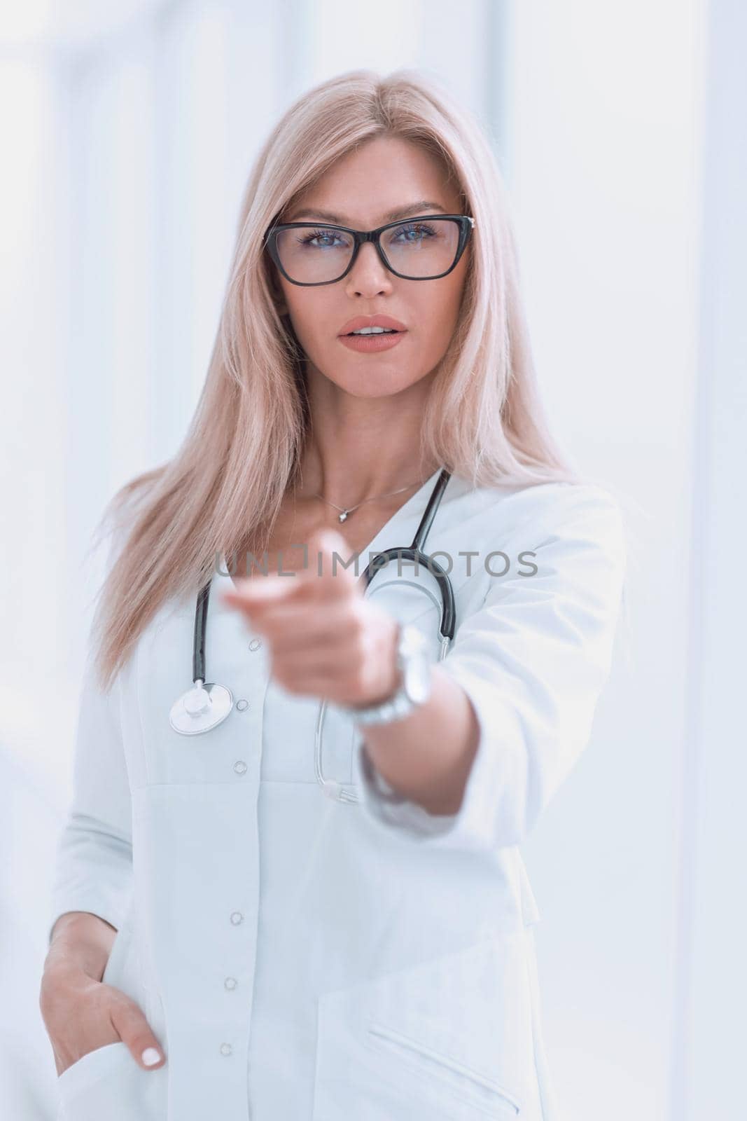 confident woman doctor diagnosing pointing at you. by asdf