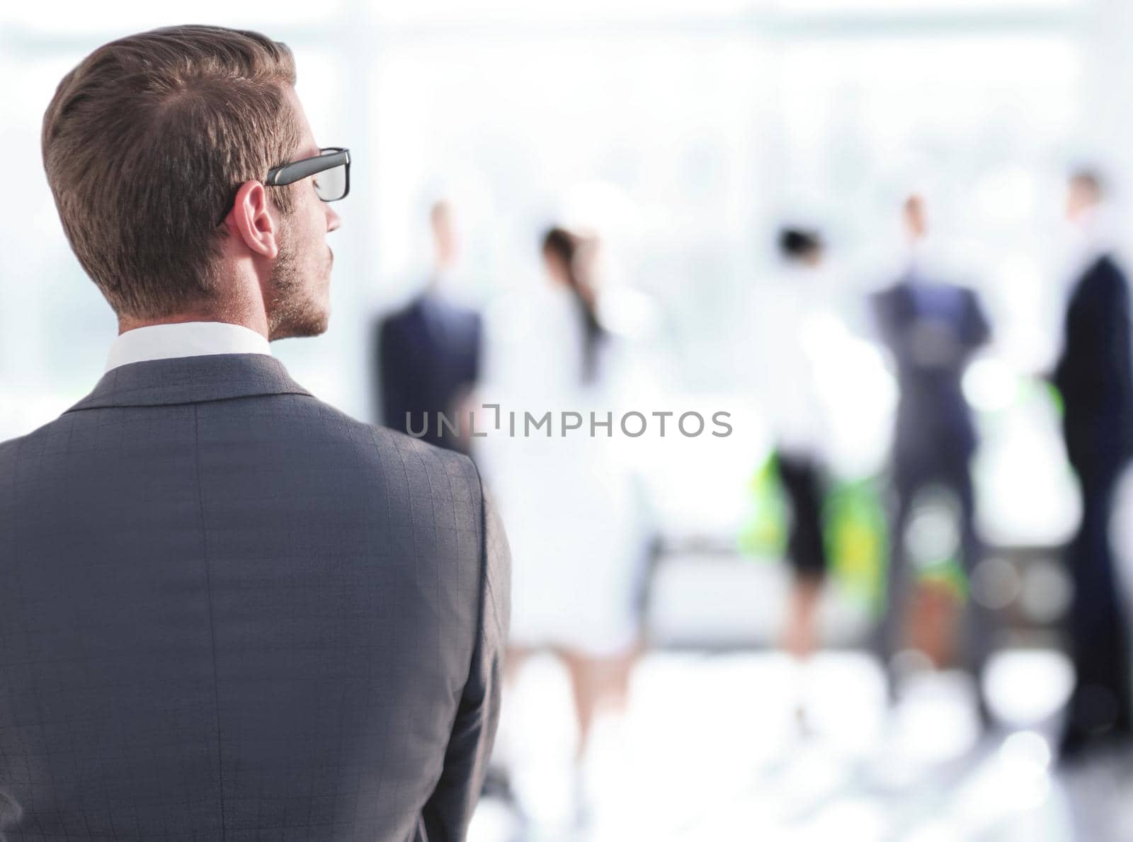rear view.businessman standing near the office window. photo with copy space