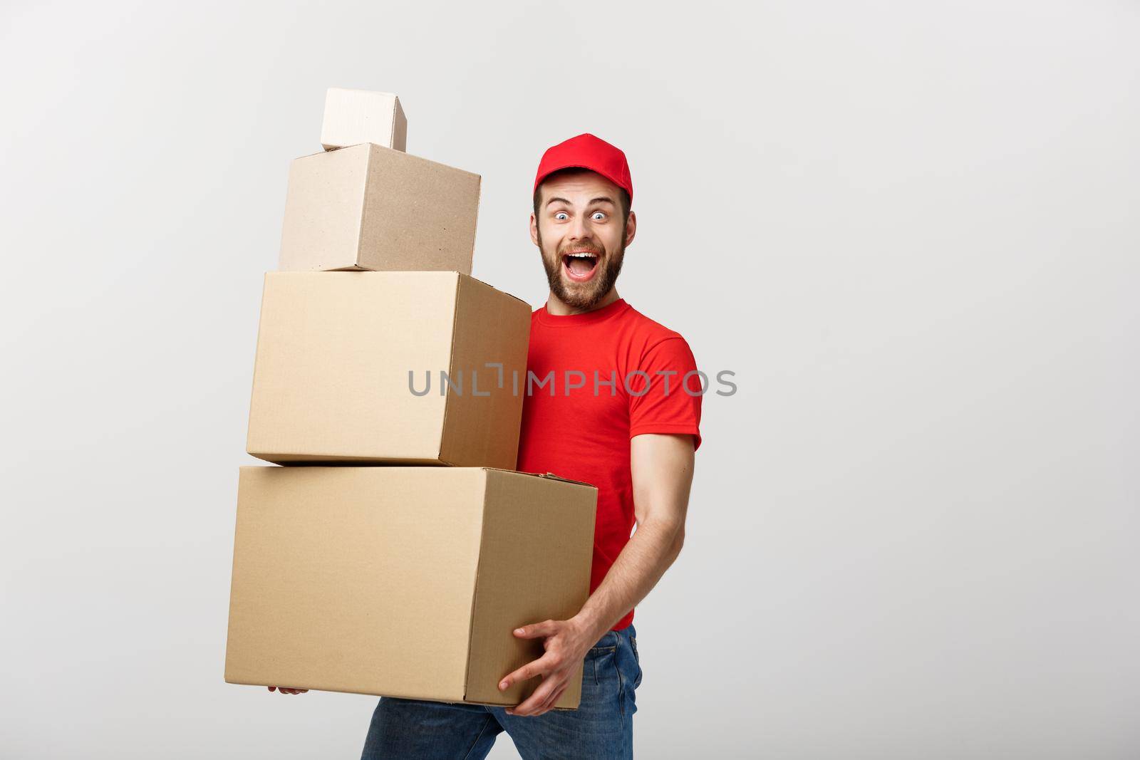 Delivery man doing surprise gesture holding cardboard boxes