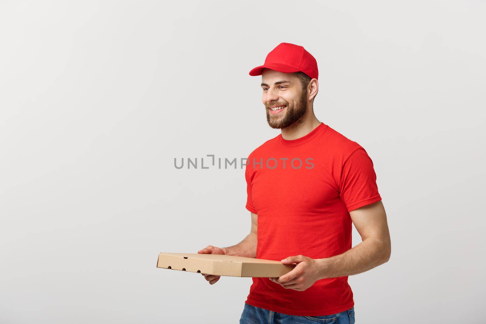 Delivery Concept: Young haapy caucasian Handsome Pizza delivery man holding pizza boxes isolated over grey background.