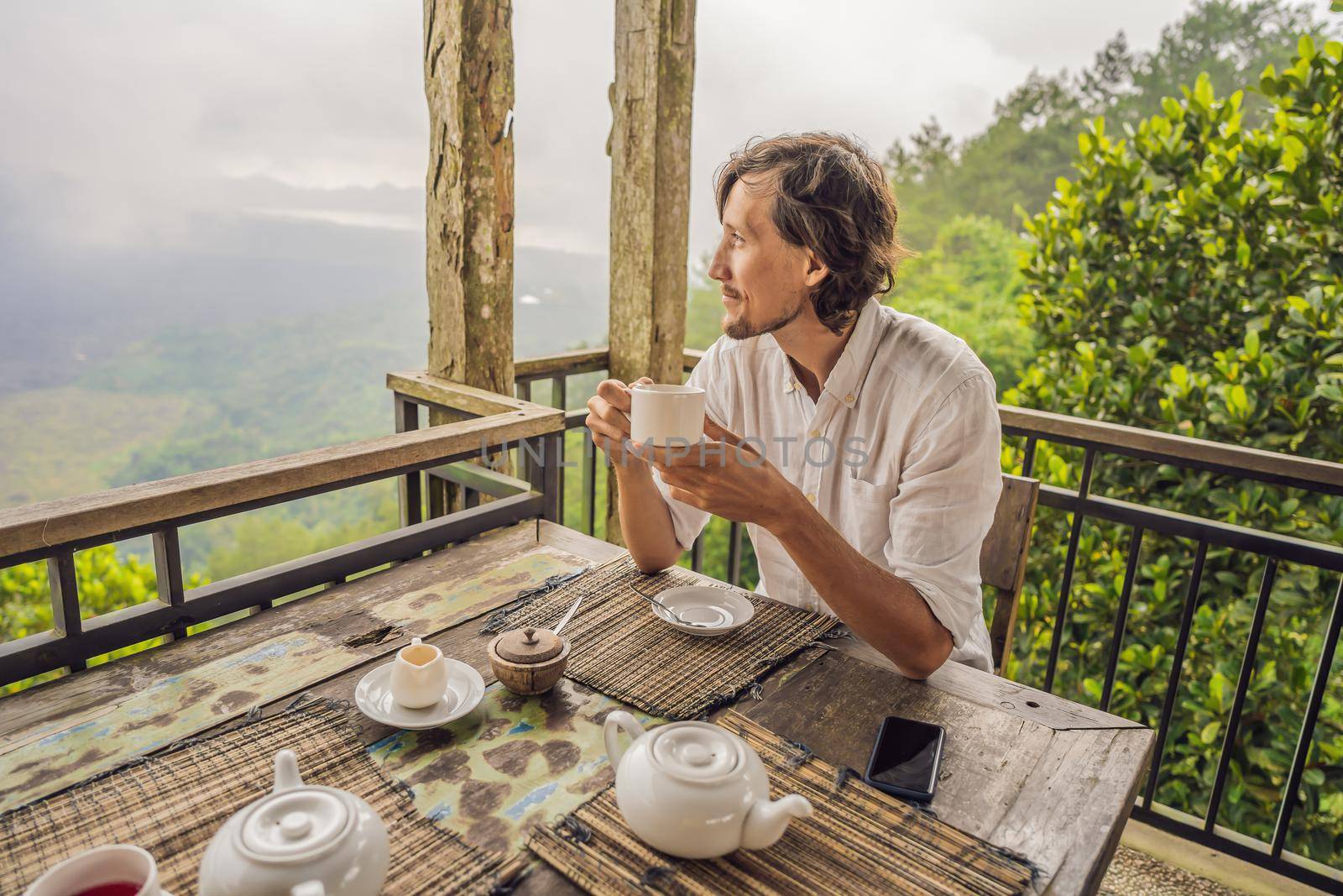 Man drinking tea in a cafe in the mountains.