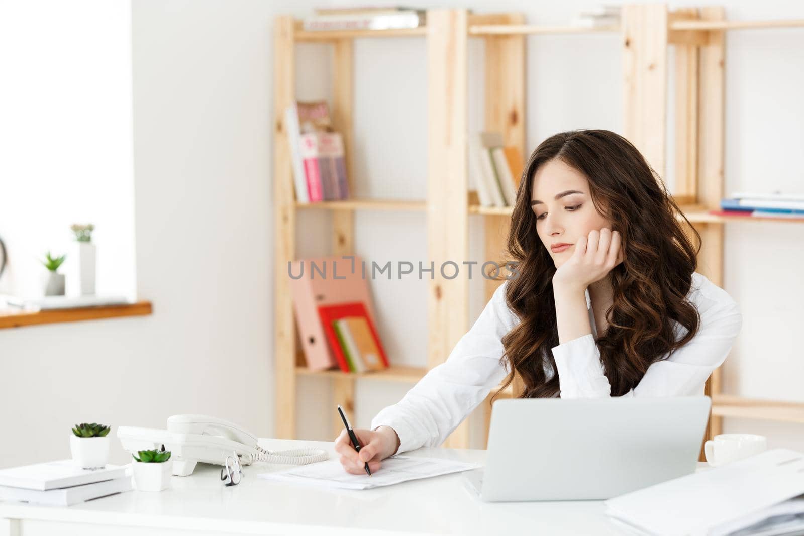 Young pretty business woman with notebook and document in the bright modern office indoors.