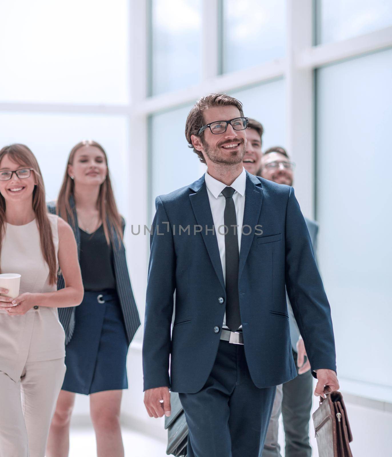 businessman walking in front of his business team . business concept