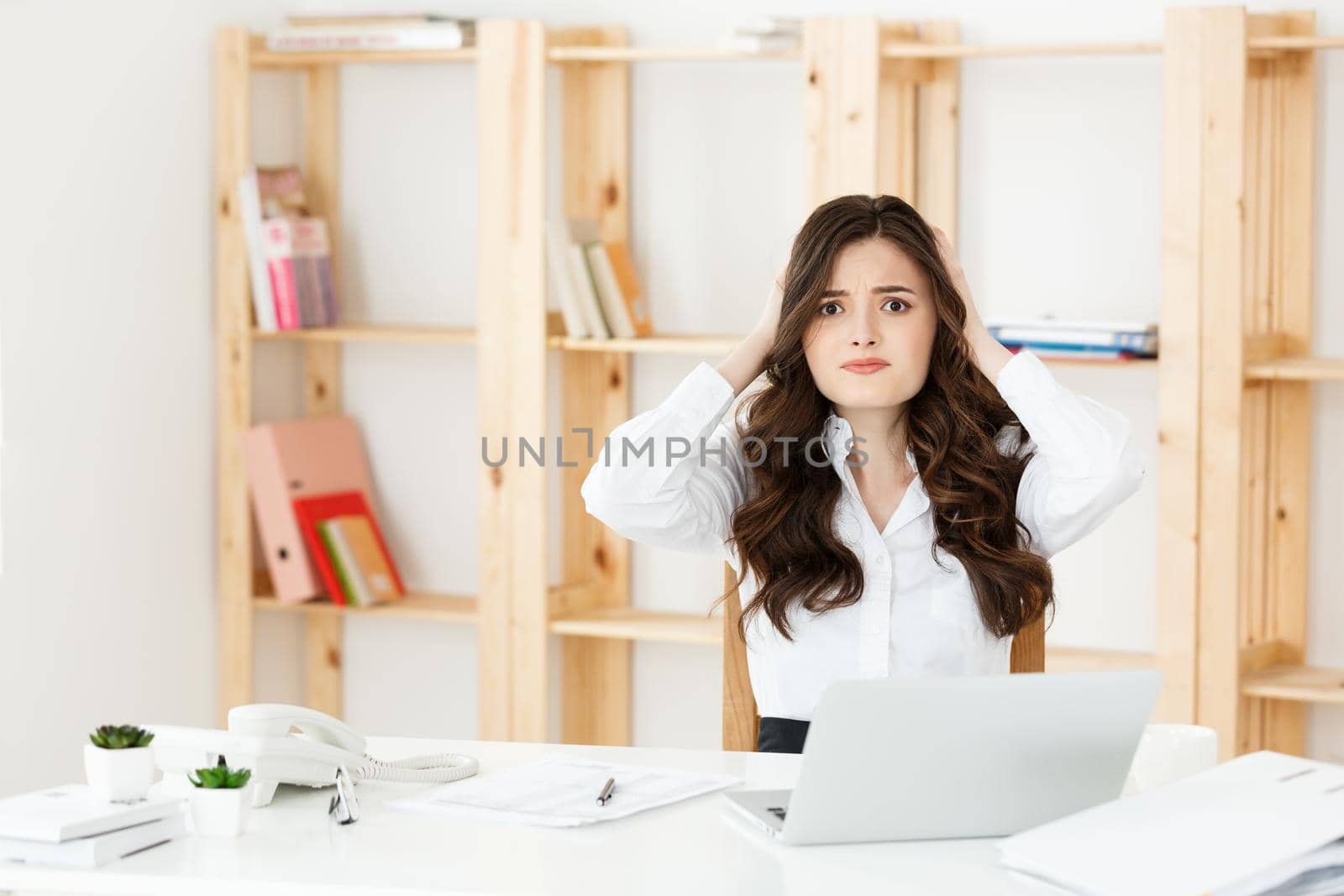 Young pretty business woman with notebook and document in the bright modern office indoors.