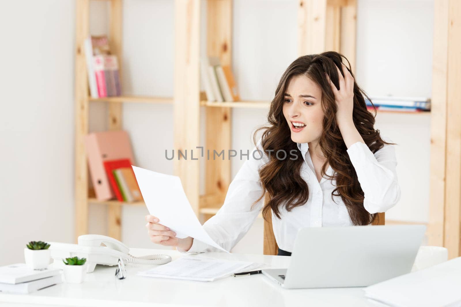 Portrait of Young Businesswoman working in her office with serious facial expression with document report