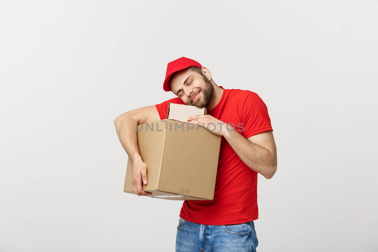 Portrait delivery man in cap with red t-shirt working as courier or dealer holding two empty cardboard boxes. Receiving package. Copy space for advertisement.