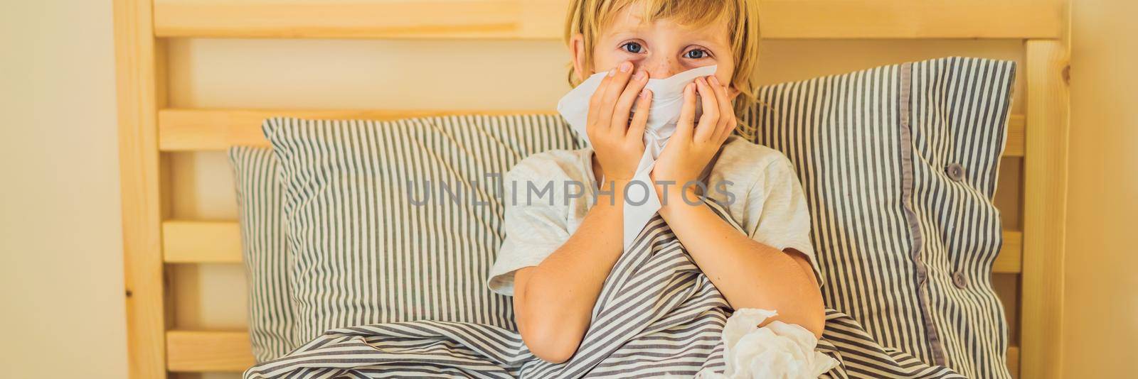 Sick boy coughs and wipes his nose with wipes. Sick child with fever and illness in bed. BANNER, LONG FORMAT