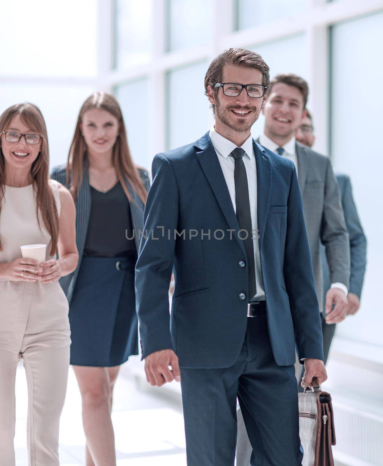 businessman walking in front of his business team . business concept