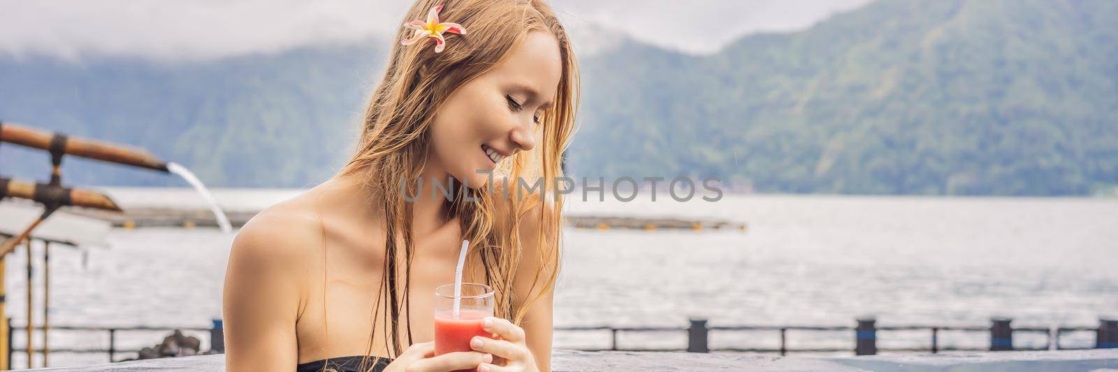 Geothermal spa. Woman relaxing in hot spring pool against the lake. hot springs concept. Drinking guava juice. BANNER, LONG FORMAT