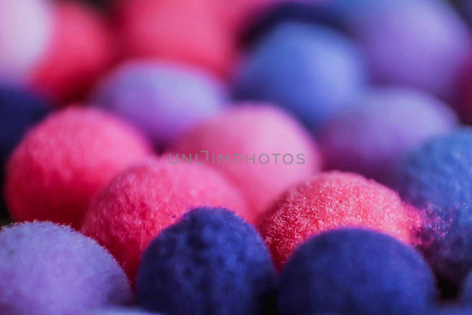 Round pink and purple fluffy balls pompoms closeup