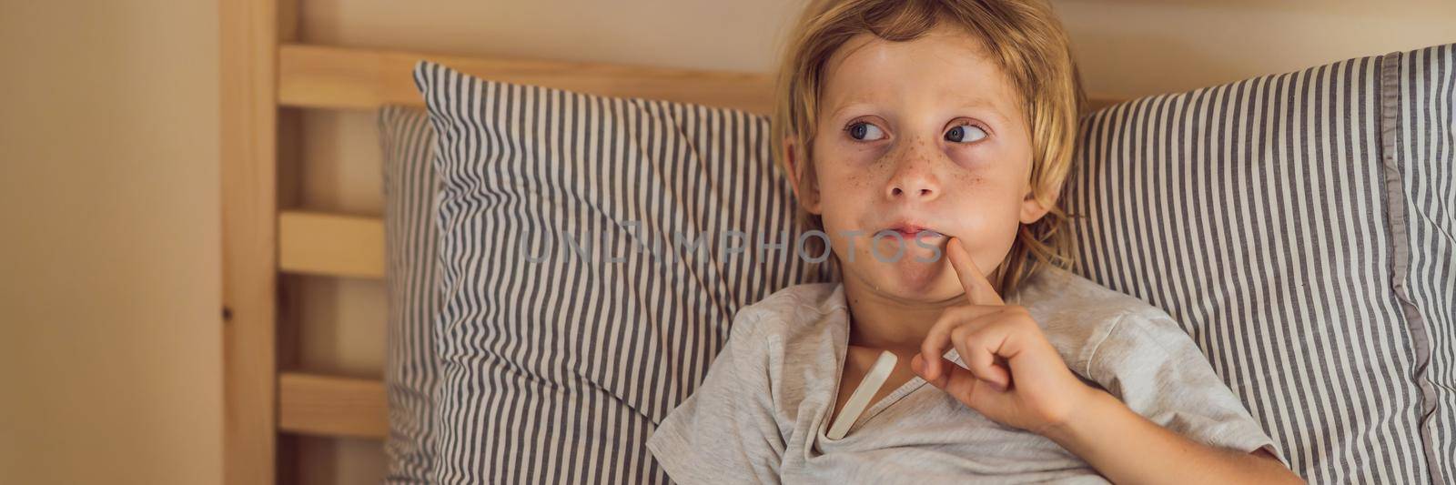 BANNER, LONG FORMAT Sick boy with thermometer laying in bed and father hand taking temperature. father checking temperature of her sick son who has thermometer. Sick child with fever and illness in bed by galitskaya